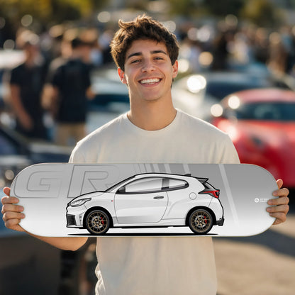 Tabla decorativa skate Toyota GR Yaris Platinum White Pearl fondo GR en un car meet – StreetRacing